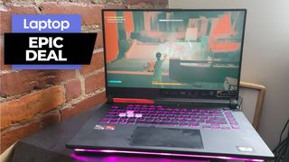 Asus gaming laptop with purple RBG backlit keyboard on black table against brick wall background