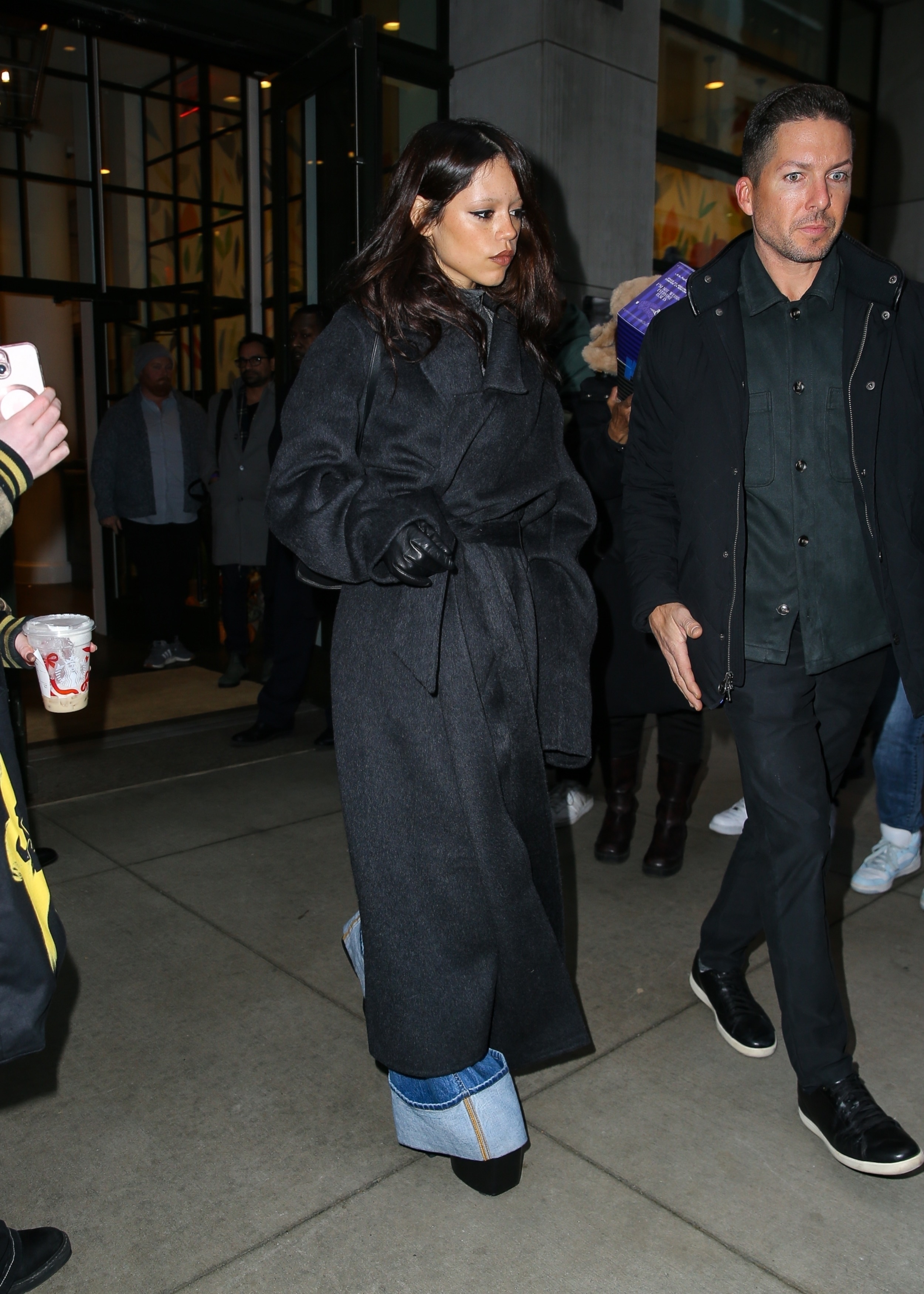 Jenna Ortega tests Fall 2025&#039;s cuffed jeans trend with a wool wrap coat and leather gloves in NYC