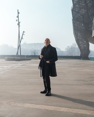 Bellini at his Milan Convention Centre, completed in 2012. Part of the 15,000 sq m silvery canopy roof tapers to the ground behind him. Photography: Albrecht Fuchs