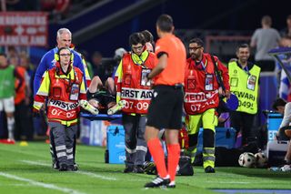 Kieran Tierney of Scotland goes off injured on a stretcher during the UEFA EURO 2024 group stage match between Scotland and Switzerland at Cologne Stadium on June 19, 2024 in Cologne, Germany