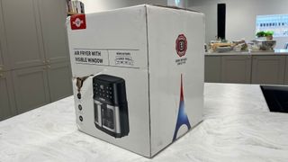 The Paris Rhone Air Fryer in its box on a countertop