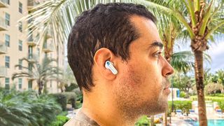 Skullcandy EcoBuds worn by reviewer testing sound quality