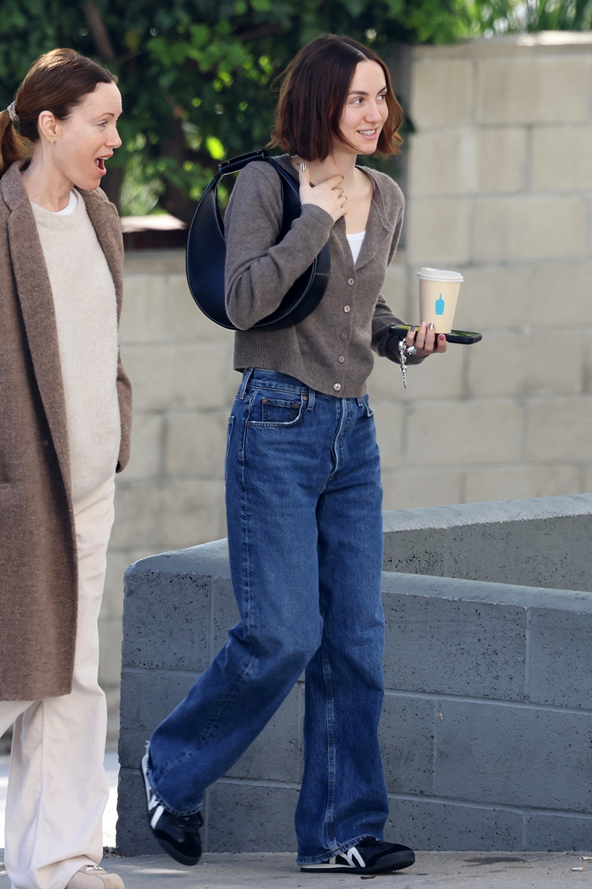 Maude Apatow wearing a brown Reformation cardigan, jeans, and black sneakers