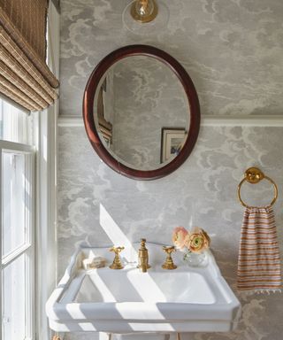 powder room with gray patterned cloud wallpaper, Victorian style pedestal and wooden oval mirror