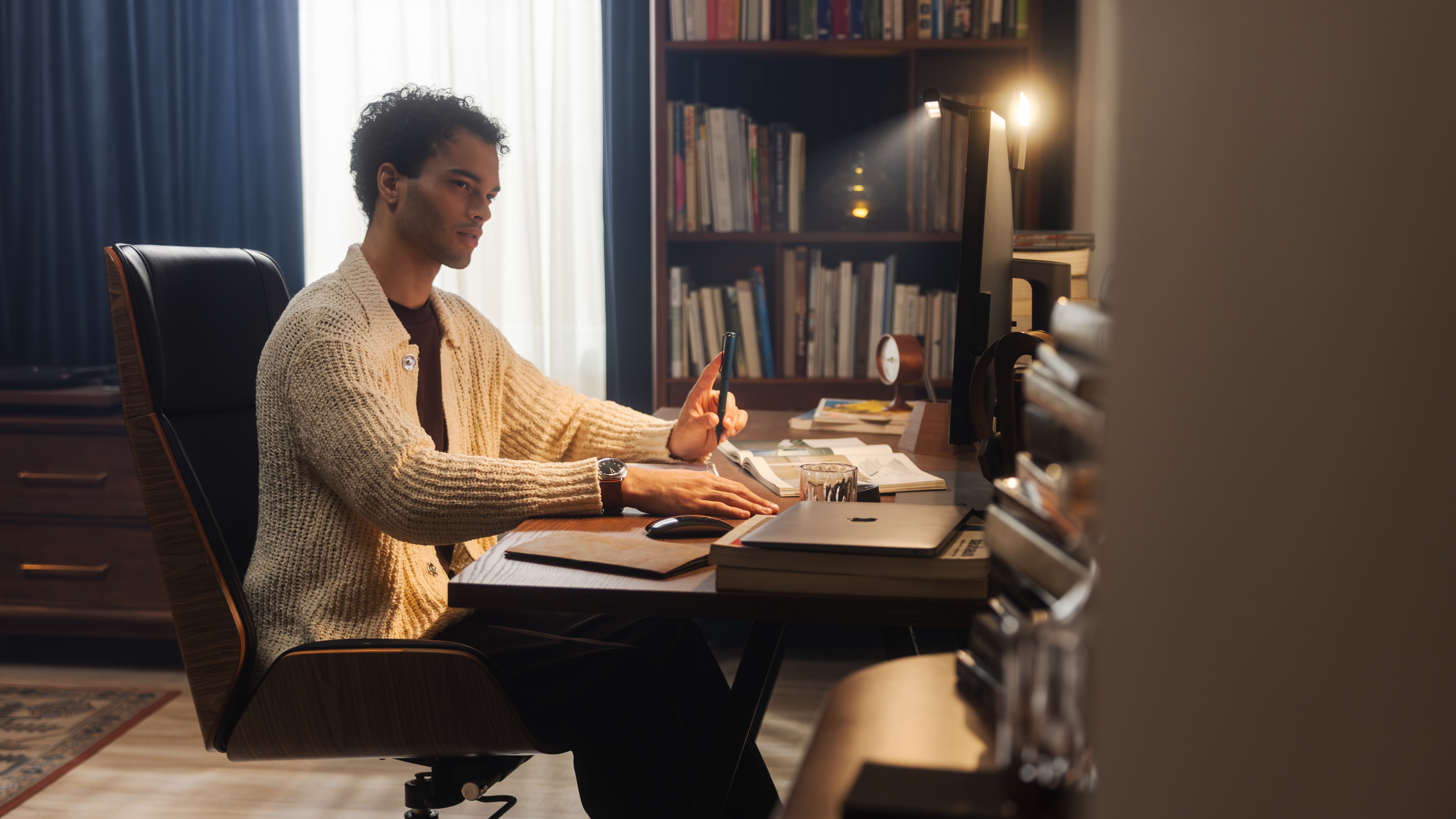 A man at his well-lit desk, thanks to a BenQ ScreenBar.