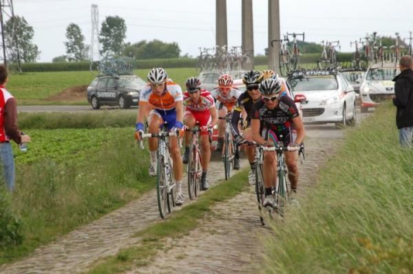 Riders line up in the wheel tracks of this cobbled road