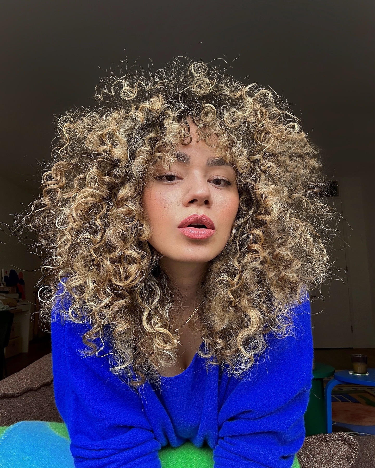 Woman taking a selfie with blonde, curly hair