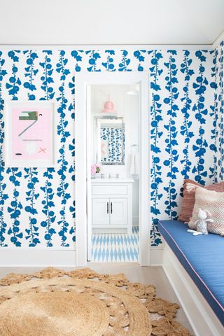 A space with pattered wallpaper and pink artworks