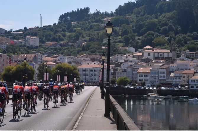 Riders cross the bridge into Pontedeume