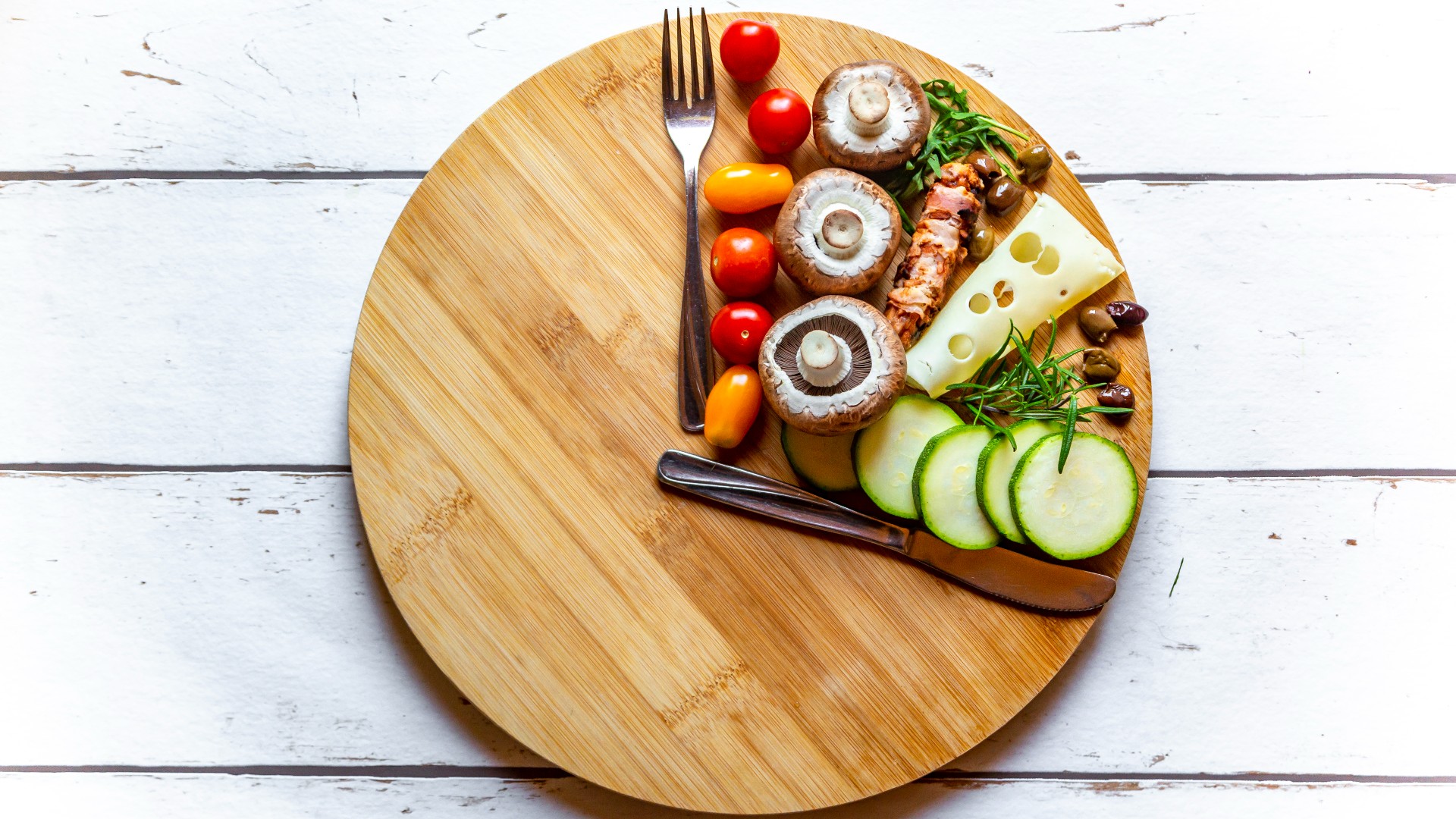 Round wooden board with a quarter portion of vegetables symbolising intermittent fasting