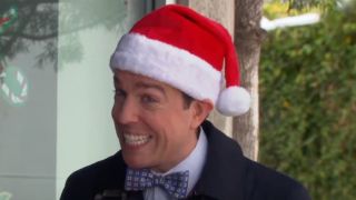 Andy giving a wide smile in a Santa Claus hat. 