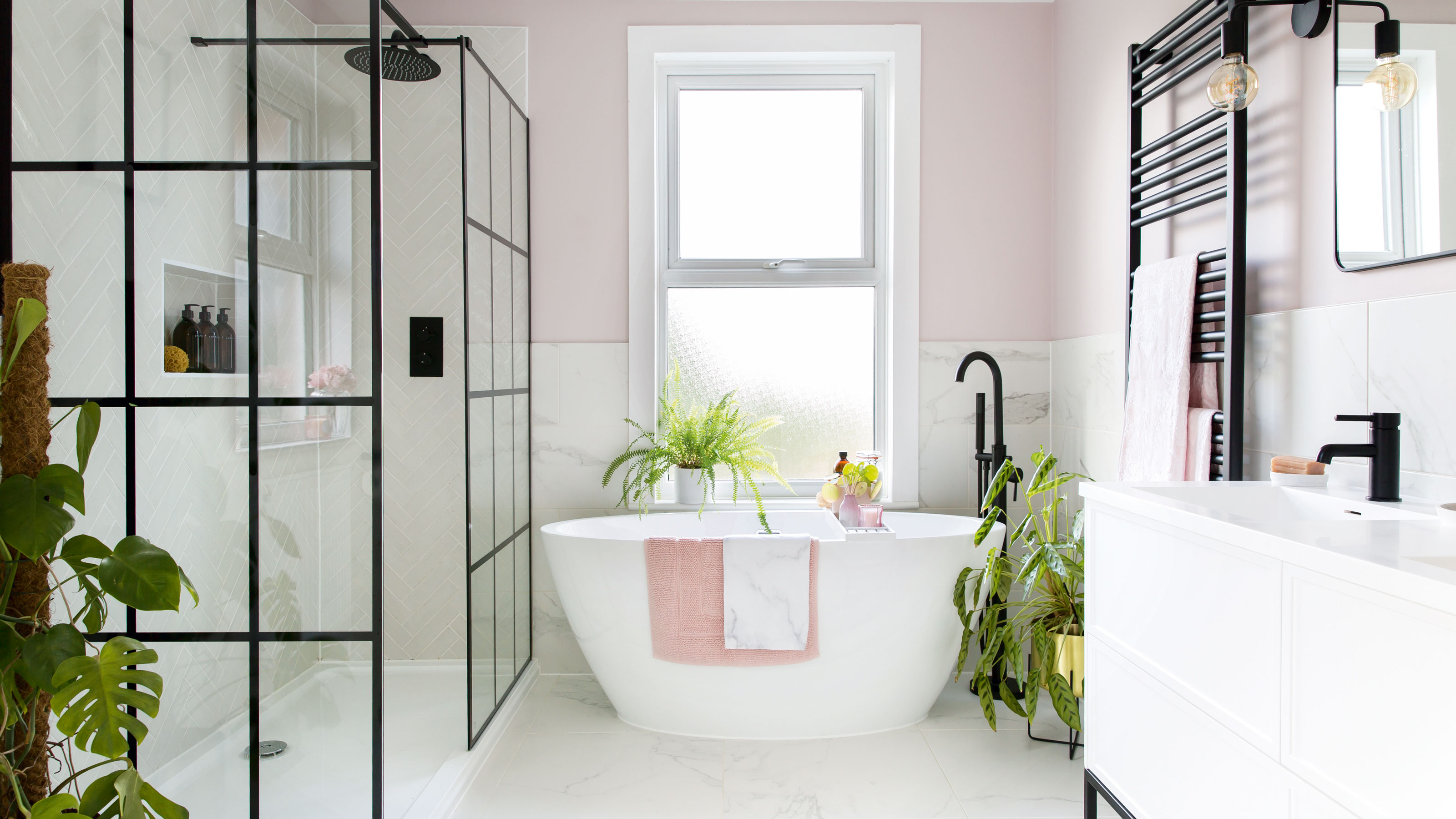 White bathroom with bathtub, shower screen and pink walls