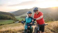 Senior couple on bike ride checking performance and route on smartwatch