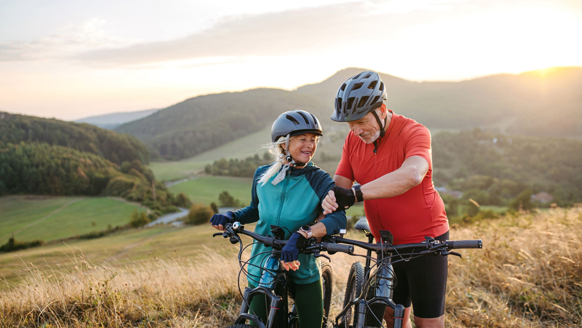 Senior couple on bike ride checking performance and route on smartwatch