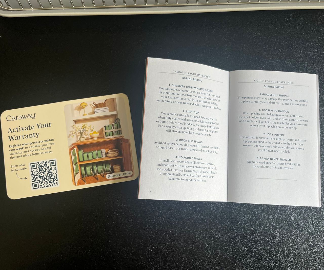 An open user manual on a black kitchen counter