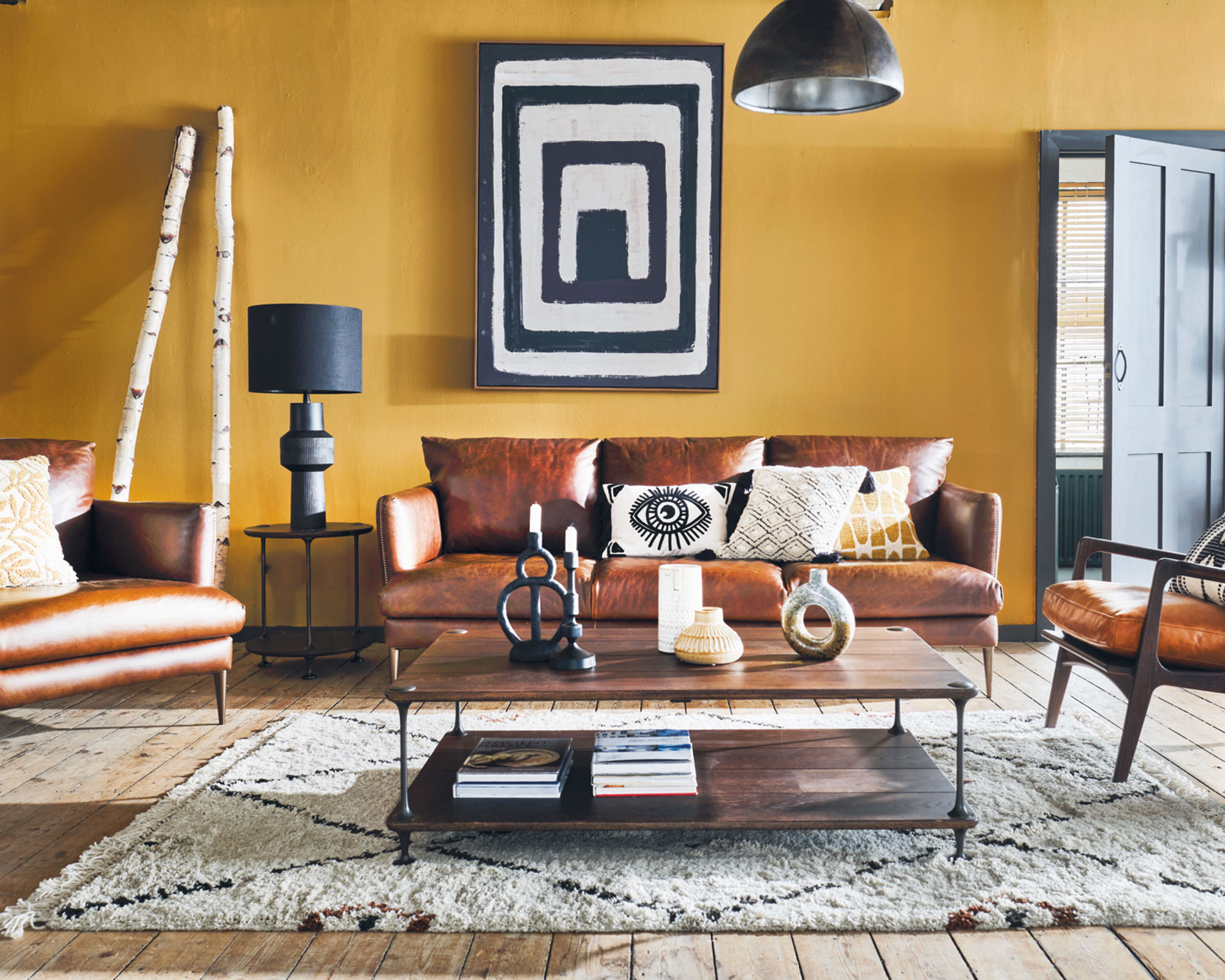 Living room fall decor with yellow wall and leather sofa