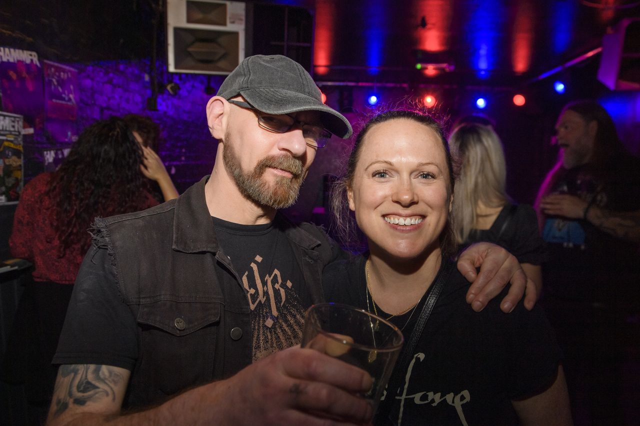 People drinking, smiling and throwing horns at the Metal Hammer 400 party