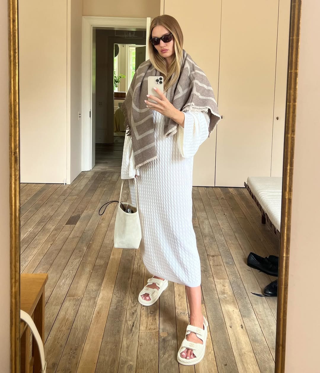 Rosie Huntington-Whiteley wears a cream cable dress, cream sandals and carries The Row Park Tote
