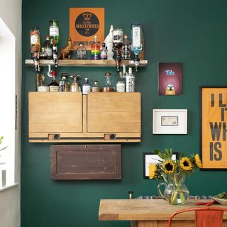 dining area with green wall and drinks and shelves and dining table with chair