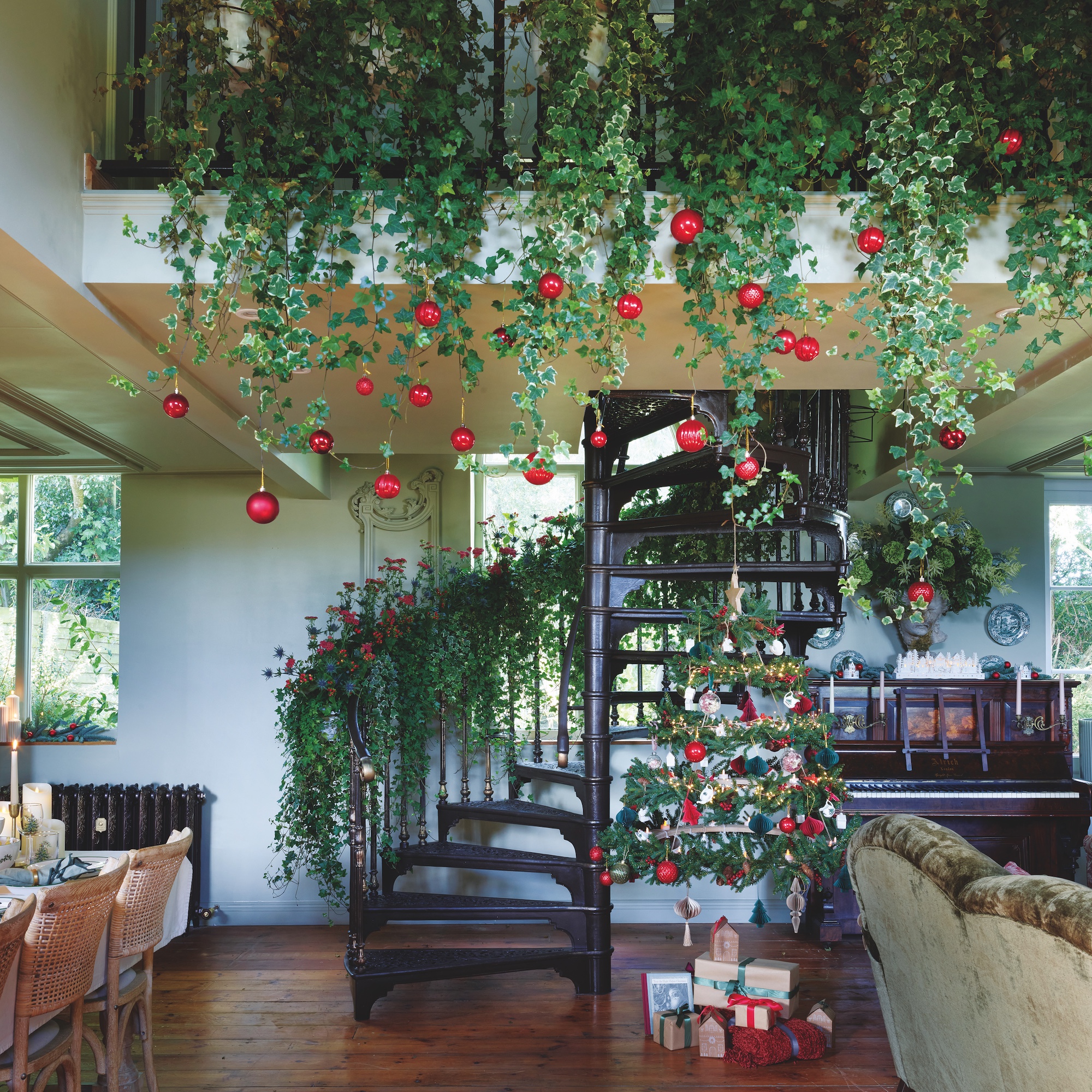 cast iron staircase and landing decorated with ivy and red baubles