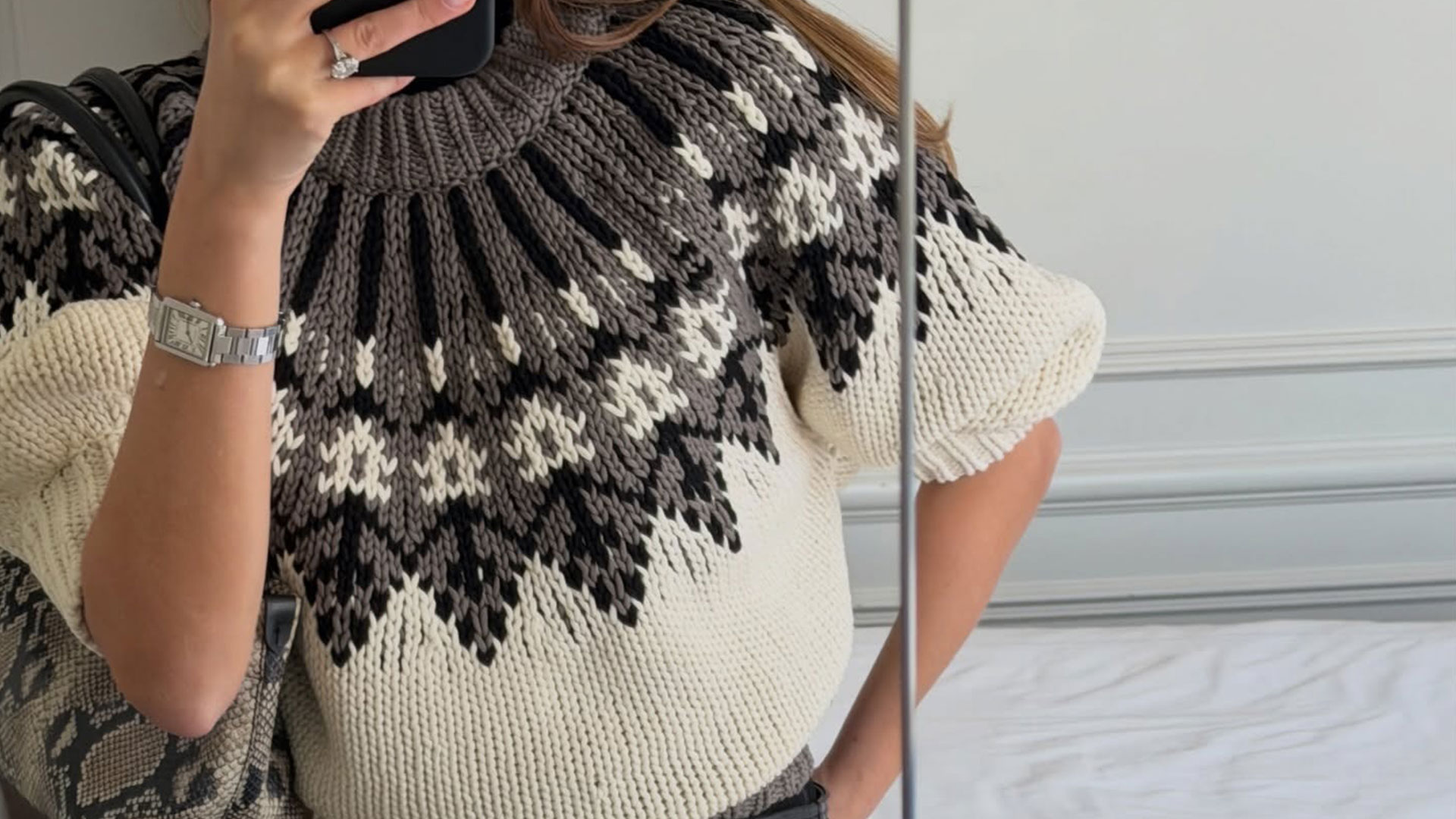 @styledsara taking a close-up mirror selfie wearing an Altuzarra Fair Isle short sleeve sweater.