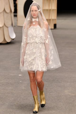 Model wears a mini wedding dress at the Chanel Haute Couture Spring Summer 2023 runway show