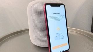 How to use your iPhone, iPad, Apple Watch, or HomePod as an Intercom. Intercom feature displayed on an iPhone 11 in front of a white HomePod.