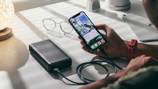 Best power banks: smartphone being charged using a power bank on desk
