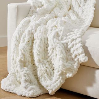 Plush Colossal Handknit Throw on an armchair. 