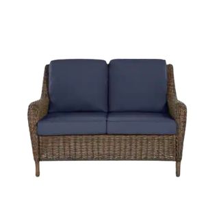 Outdoor wicker love seat with blue cushion