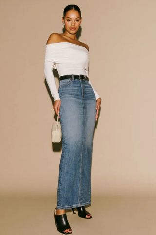 reformation winter sale woman wearing denim maxi skirt with white long sleeve top and mules