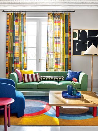 Colorful living room with green sofa and curtains in Pierre Frey's Festival Multicolore fabric