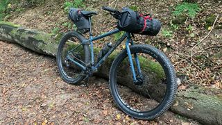 Genesis Longitude rigid adventure bike in woods with bikepacking kit