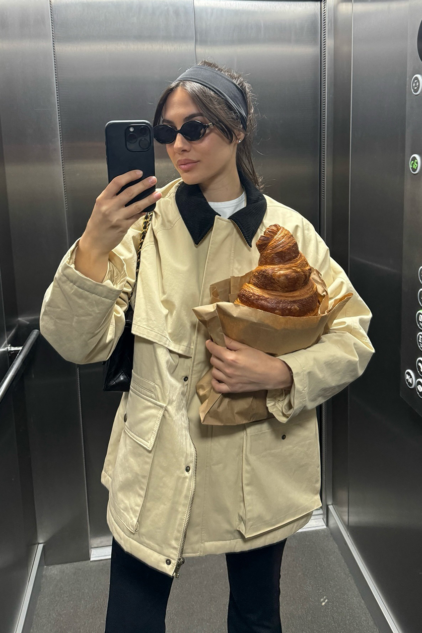 a woman wearing a cream barn jacket and miu miu sunglasses