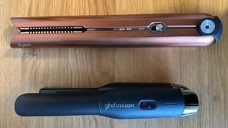 Dyson Corrale cordless straightener in gold next to ghd Unplugged in black