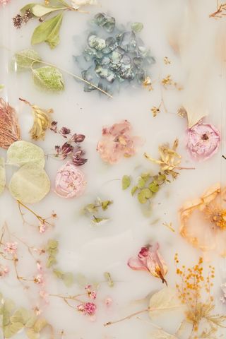 Colourful dried flowers peeking from under a white resin surface