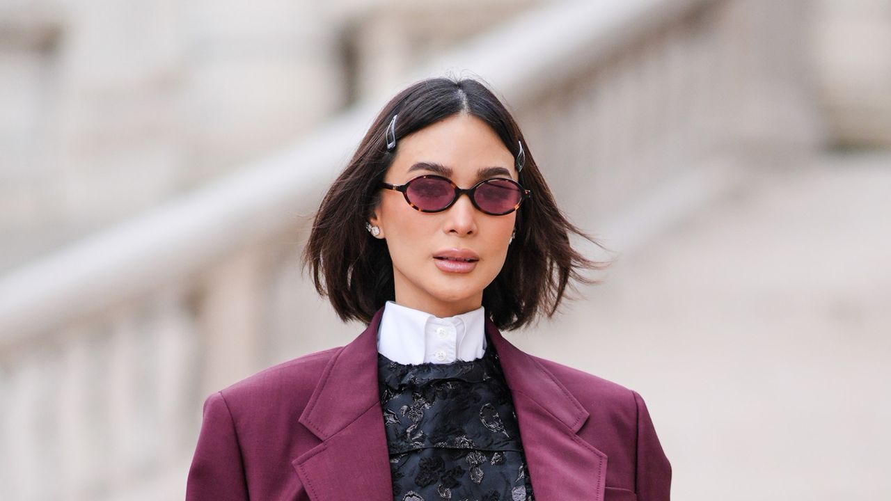 Heart Evangelista wears hair pins, a white shirt, a burgundy oversized blazer jacket , a black floral print mini dress , a black leather bag , outside Miu Miu , during the Womenswear Fall/Winter 2024/2025 as part of Paris Fashion Week on March 05, 2024 in Paris, France