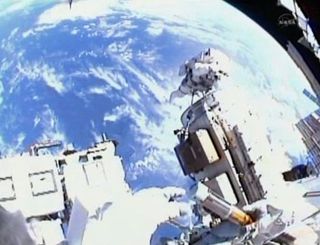 The view from spacewalker Alvin Drew's helmet cam shows him opening the "Message in a Bottle" to capture space. 