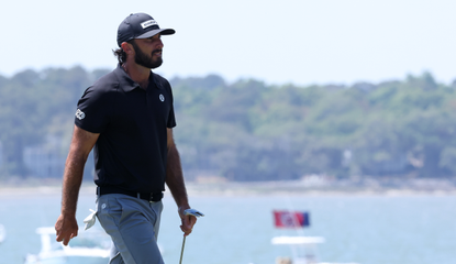 Max Homa walks off the green holding a putter