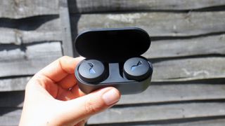 a hand holding the nuratrue wireless earbuds in their charging case