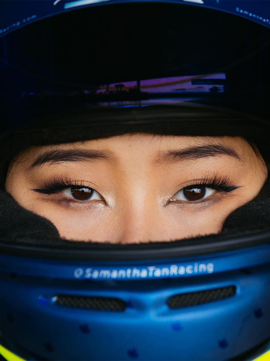 Pro racing driver Samantha Tan wearing a helmet with winged eyeliner.