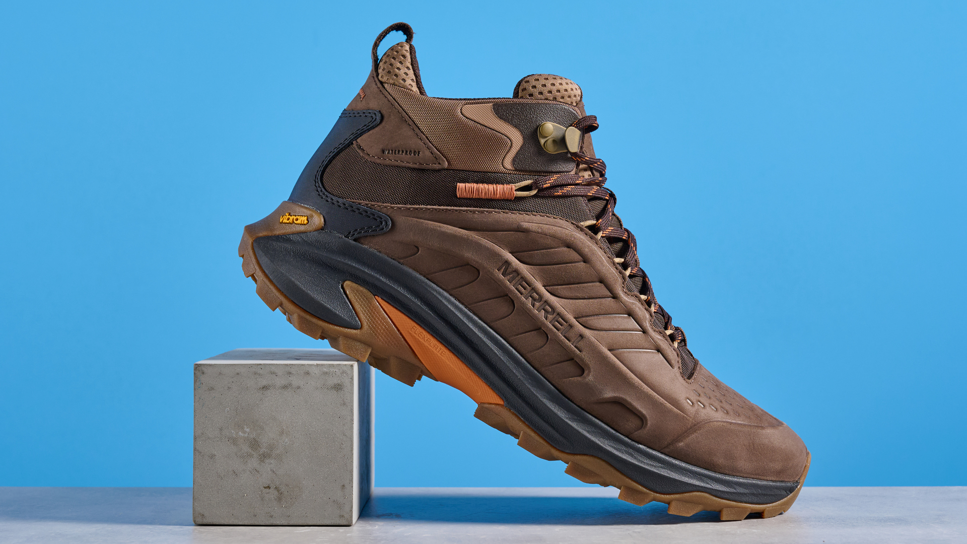 A photo of the Merrell Moab Speed 2 boots against a blue background