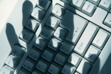 shadowy hands over a keyboard