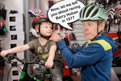Hutch puts a helmet onto a child in a bike shop