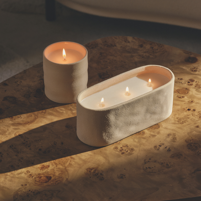M&S new 1 wick and 3 wick ceramic candles on a burl wood table.
