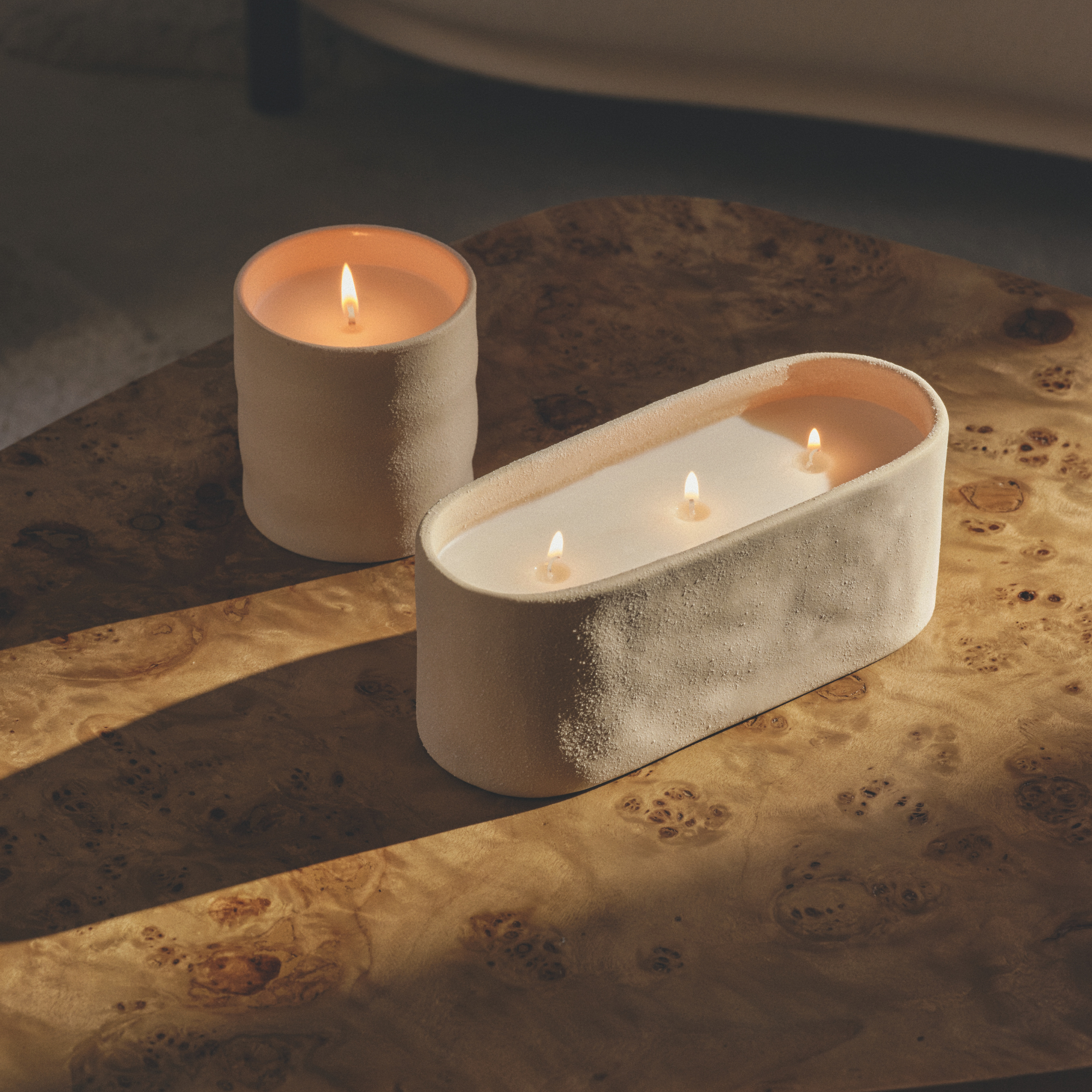 M&amp;S new 1 wick and 3 wick ceramic candles on a burl wood table.