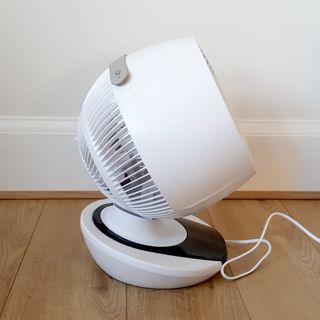 A side view of the white MeacoFan 1056 Air Circulator on a wooden floor