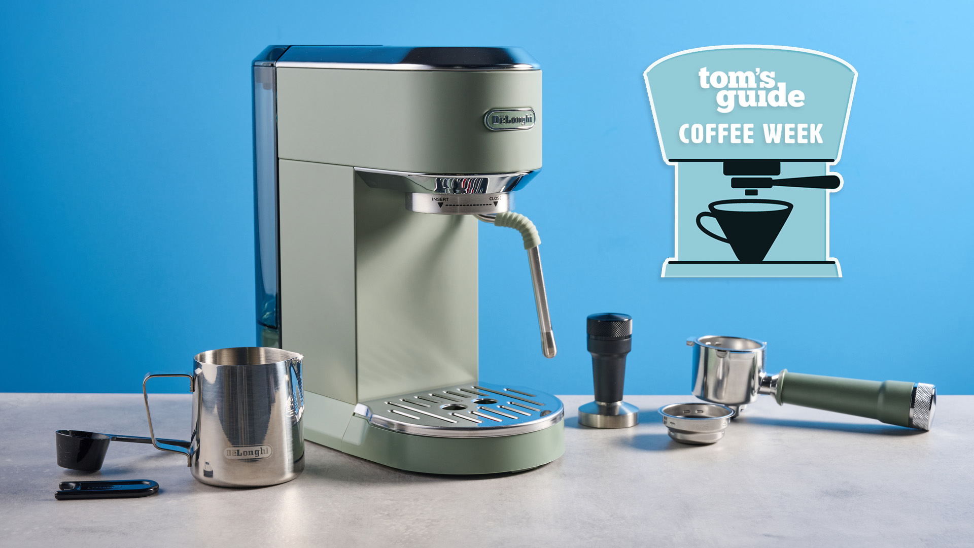 DeLonghi Dedica Duo in the green colorway with accessories photographed on a blue background. 
