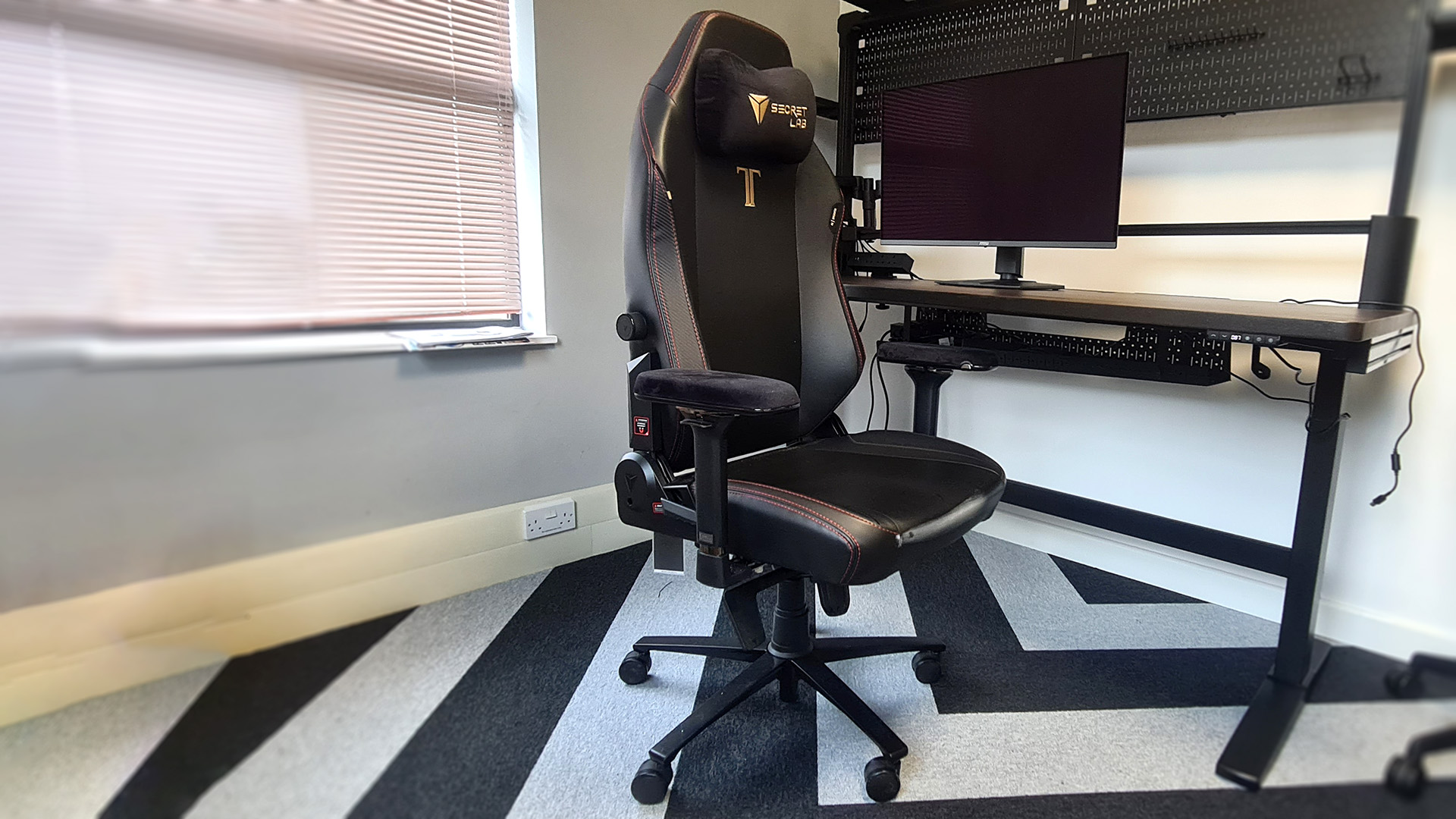 The Secretlab Titan Evo next to a desk in the PC Gamer office.