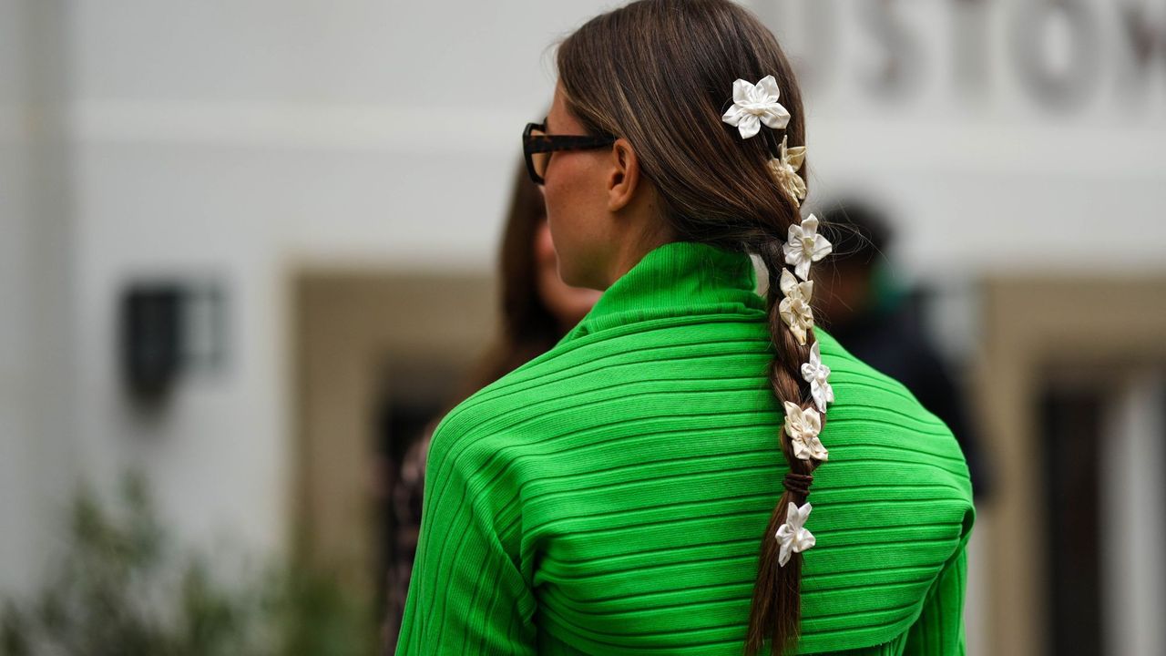 Casual plait hairstyles Brunette woman with plait with flowers in GettyImages-1606540718